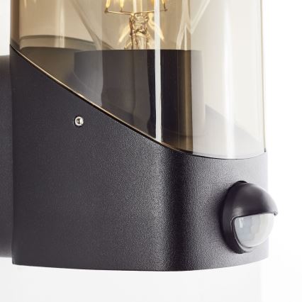 Brilliant - Spoljna zidna svetiljka sa senzorom MINOU 1xE27/10W/230V IP44 crna/zadimljena